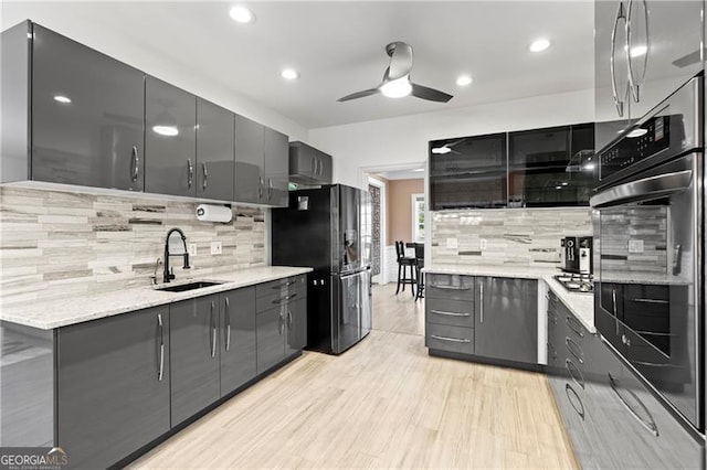 kitchen featuring appliances with stainless steel finishes, tasteful backsplash, light hardwood / wood-style flooring, and sink