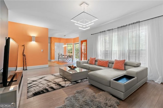 living room featuring a notable chandelier and light hardwood / wood-style floors