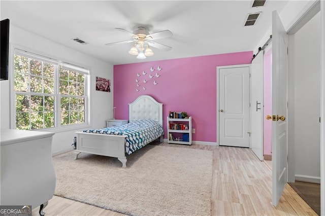 bedroom with ceiling fan, light hardwood / wood-style floors, and lofted ceiling