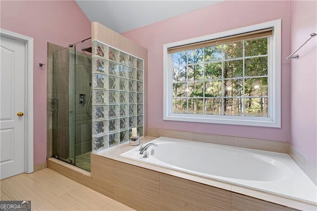 bathroom featuring shower with separate bathtub