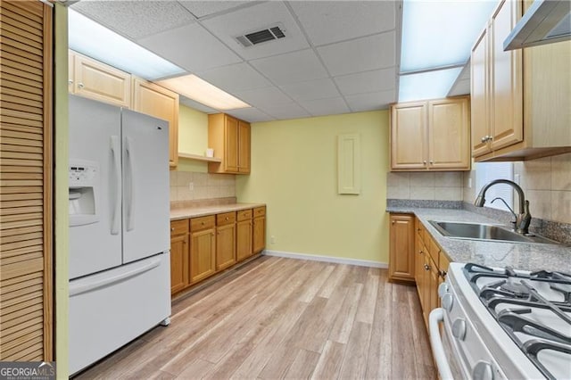 kitchen with sink, extractor fan, white appliances, decorative backsplash, and light wood-type flooring