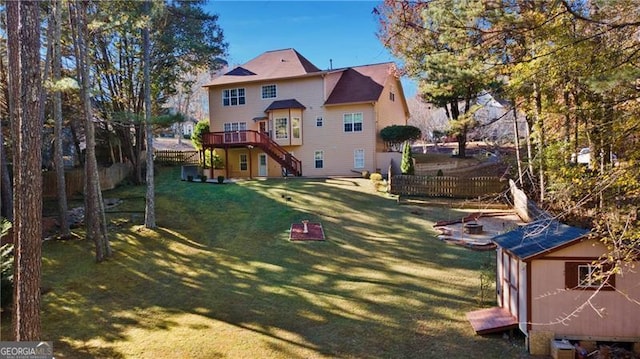 back of house with a yard, a shed, and a wooden deck