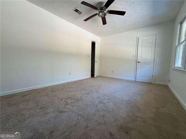 carpeted empty room with ceiling fan and a textured ceiling