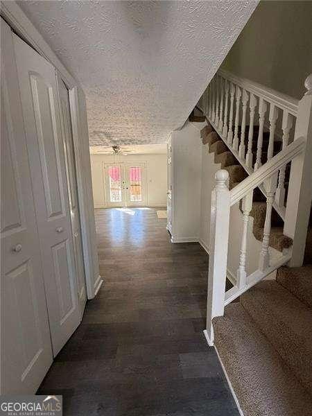 hall with dark hardwood / wood-style flooring and a textured ceiling