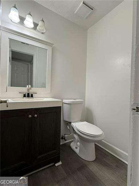 bathroom featuring vanity, toilet, and wood-type flooring