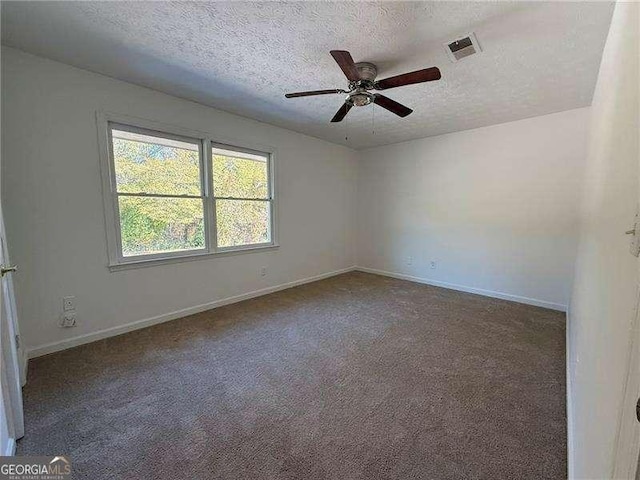 carpeted spare room with a textured ceiling and ceiling fan