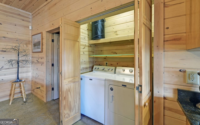 laundry room featuring washer and dryer, dark colored carpet, and wooden walls