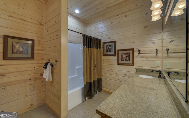 bathroom with wood walls, tile patterned flooring, vanity, and shower / bath combo