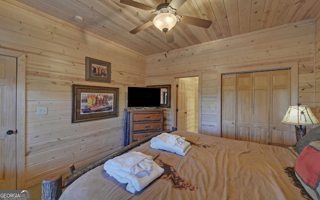 bedroom featuring a closet, wooden ceiling, ceiling fan, and wooden walls