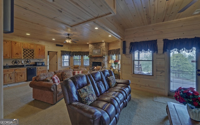 carpeted living room with wood walls, a fireplace, ceiling fan, and wood ceiling