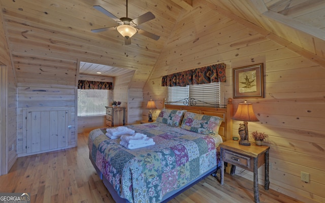 bedroom with wooden walls, ceiling fan, lofted ceiling, and light wood-type flooring