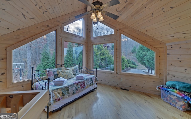 bedroom with multiple windows and wood walls