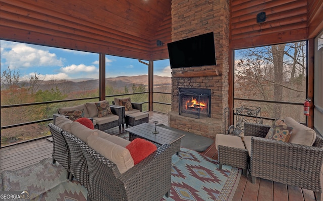 sunroom / solarium featuring an outdoor stone fireplace