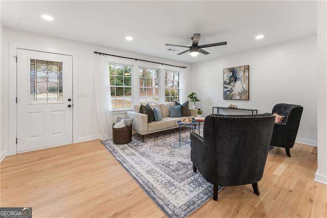 living room with ceiling fan and light hardwood / wood-style floors