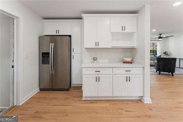 kitchen featuring stainless steel fridge with ice dispenser, light hardwood / wood-style floors, white cabinetry, and ceiling fan