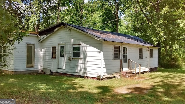 rear view of property with a lawn