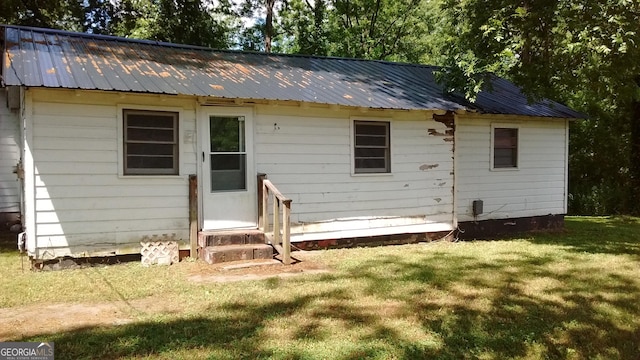 back of house featuring a lawn