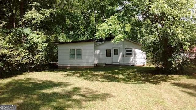 rear view of property featuring a lawn