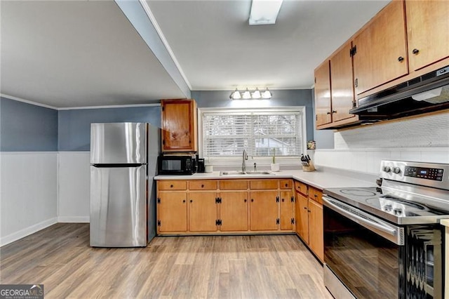 kitchen featuring ornamental molding, sink, stainless steel appliances, and light wood-type flooring