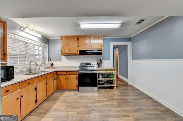 kitchen with stainless steel range with electric stovetop, crown molding, sink, range hood, and light hardwood / wood-style floors