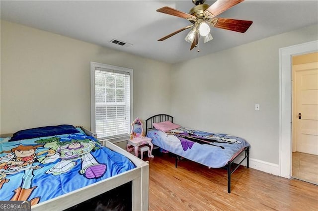 bedroom with light hardwood / wood-style floors and ceiling fan