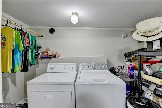 laundry area featuring crown molding and washing machine and clothes dryer