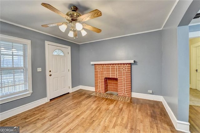 unfurnished living room with a fireplace, light wood-type flooring, ceiling fan, and crown molding