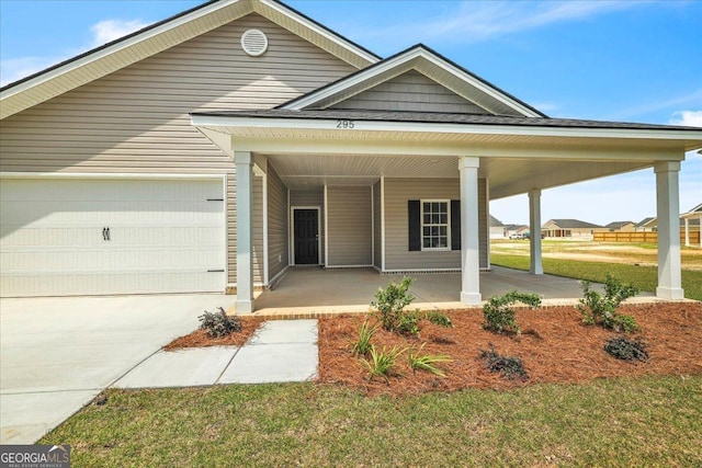 295 Lanier Rd NE, Ludowici, GA 31316 - view of front of property with covered porch, an attached garage, concrete driveway, and a front yard