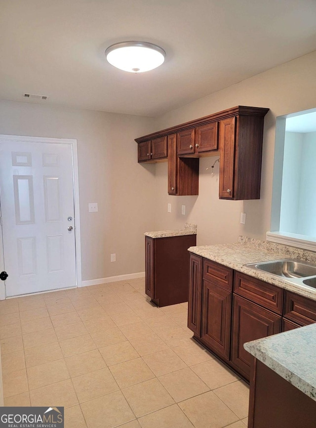 kitchen featuring dark brown cabinetry and sink