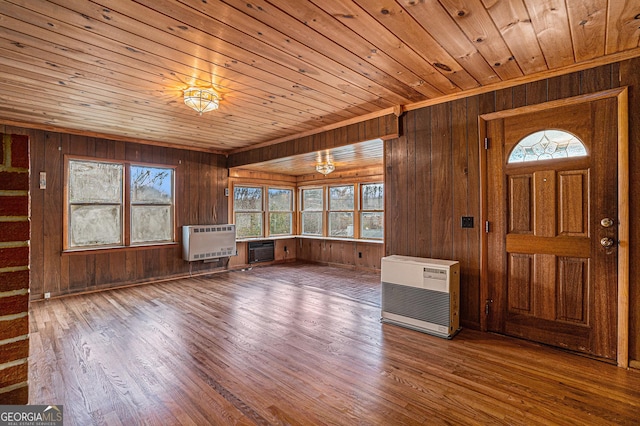 foyer featuring heating unit, wood walls, hardwood / wood-style floors, and wood ceiling