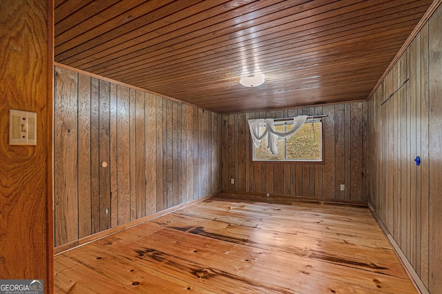 unfurnished room featuring wood ceiling, wood walls, and light hardwood / wood-style floors