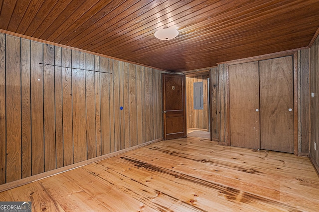 unfurnished bedroom with light hardwood / wood-style floors, wood ceiling, and wooden walls