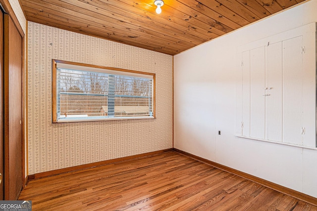 unfurnished bedroom with a closet, wooden ceiling, and light wood-type flooring