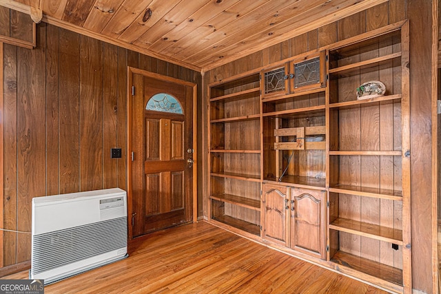 unfurnished office featuring heating unit, wooden walls, wood ceiling, and light wood-type flooring