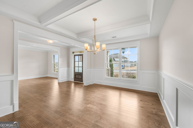 unfurnished dining area featuring beamed ceiling, wood-type flooring, and a chandelier