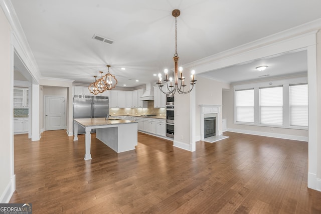 kitchen with premium range hood, dark wood-type flooring, decorative light fixtures, a center island, and white cabinetry