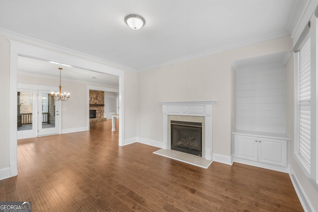 unfurnished living room featuring an inviting chandelier, dark hardwood / wood-style floors, and ornamental molding