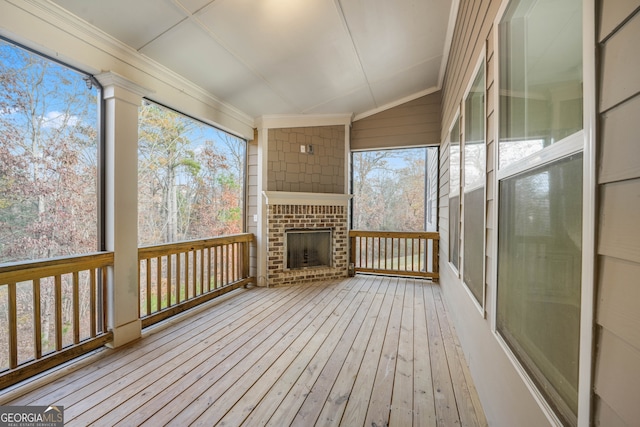 wooden deck featuring a brick fireplace