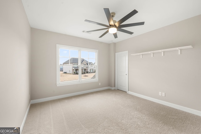 carpeted spare room with ceiling fan