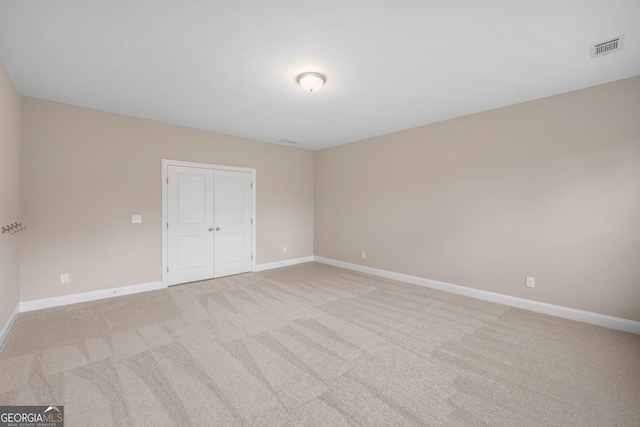 unfurnished room featuring light carpet