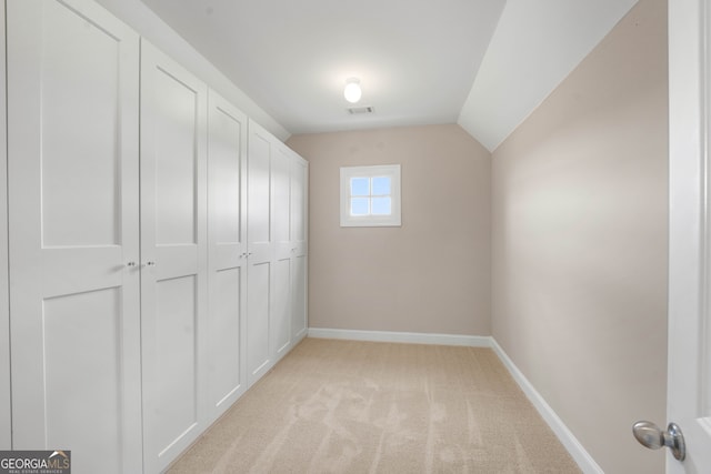 interior space with light carpet and lofted ceiling