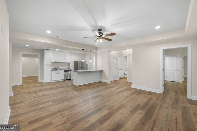 unfurnished living room featuring ceiling fan and hardwood / wood-style floors