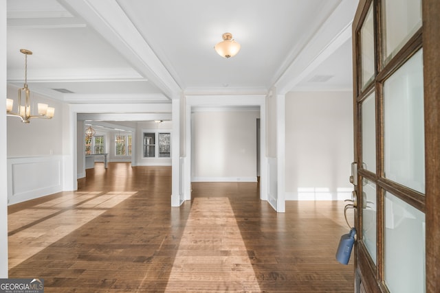 entrance foyer featuring ornamental molding, dark hardwood / wood-style floors, and a notable chandelier