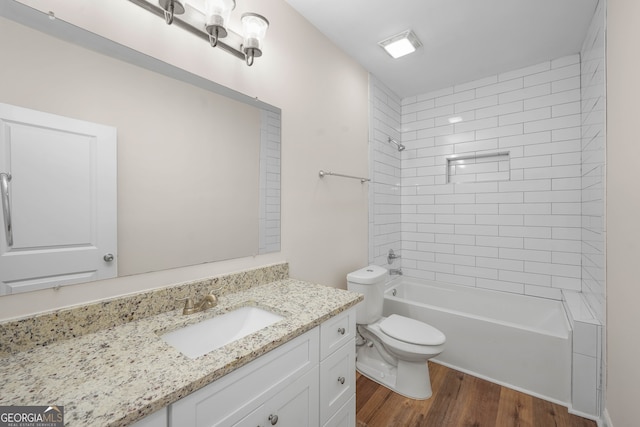 full bathroom with toilet, vanity, tiled shower / bath combo, and hardwood / wood-style flooring