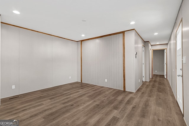 unfurnished room featuring wood-type flooring and ornamental molding