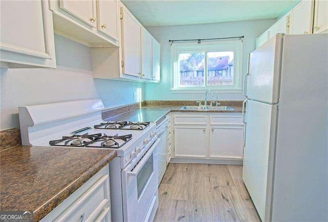 kitchen featuring sink, white appliances, light hardwood / wood-style flooring, and white cabinets