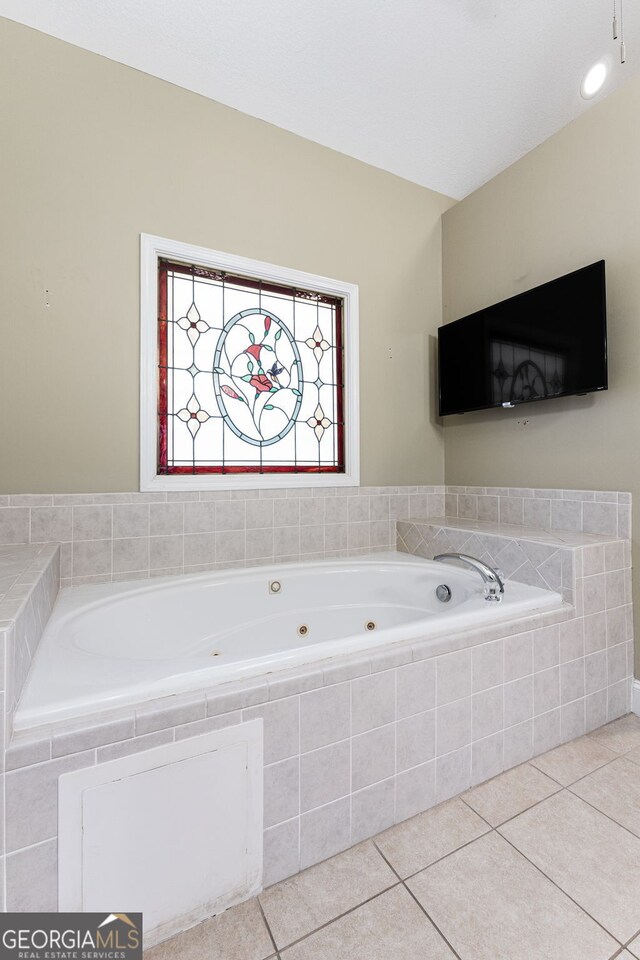 bathroom featuring tile patterned floors and tiled tub