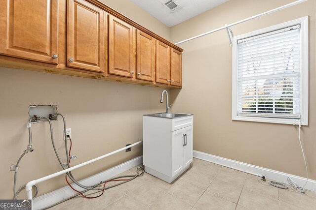 laundry room featuring light tile patterned flooring, hookup for a washing machine, cabinets, and sink