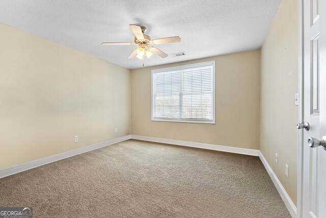 empty room featuring ceiling fan, carpet floors, and a textured ceiling