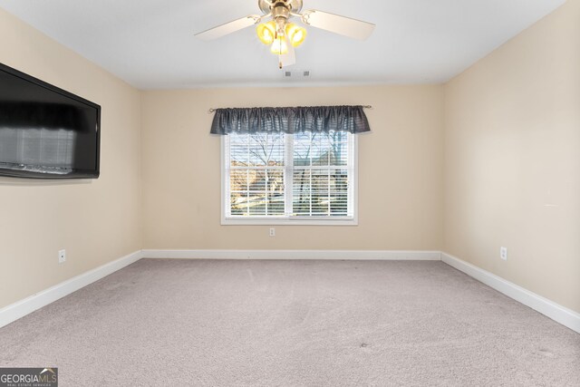 empty room with ceiling fan and carpet floors